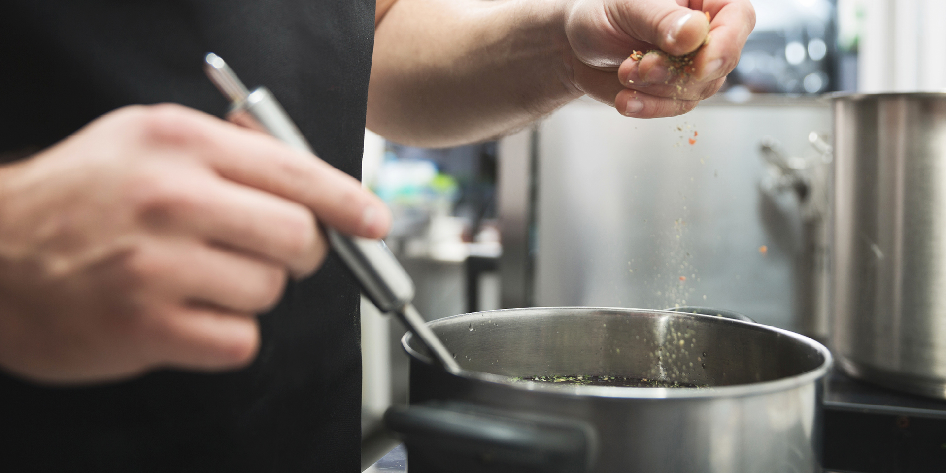 man sprinkling seasonings into a pot