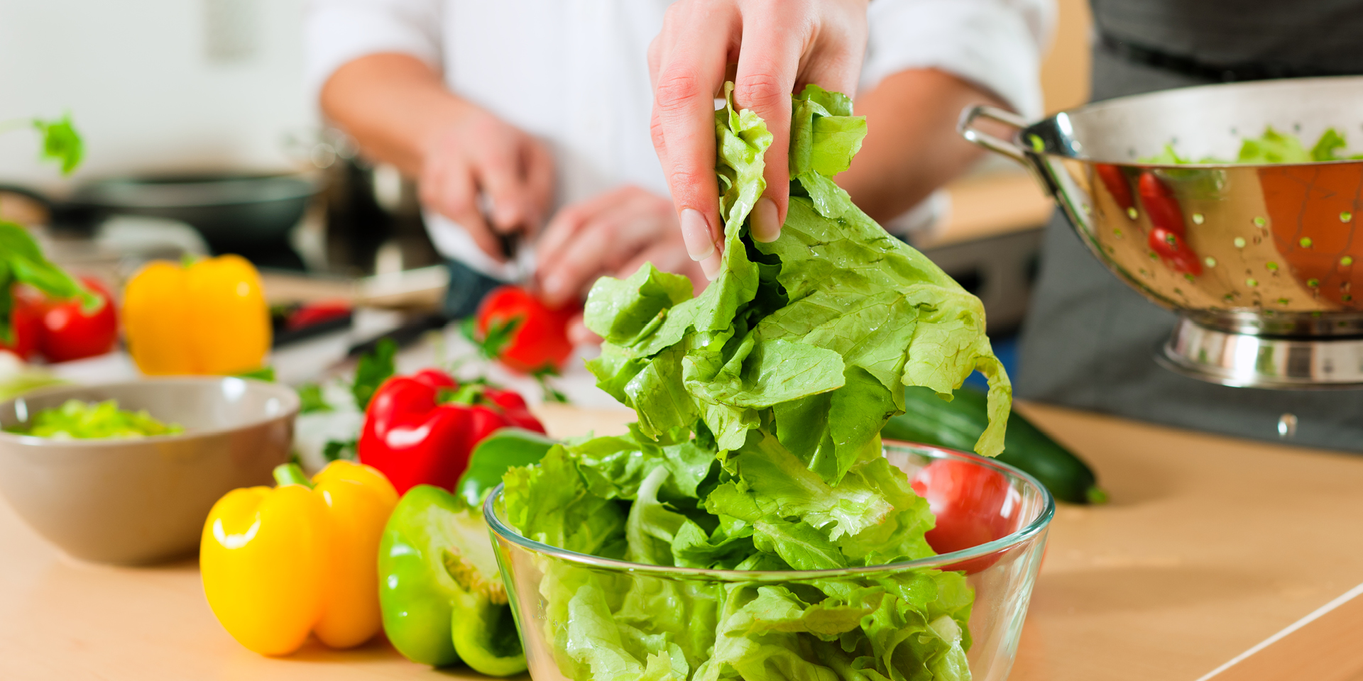 a couple preparing salad in their kitchen